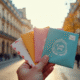 Main tenant plusieurs enveloppes colorées de Paris avec codes postaux