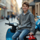 Jeune garçon souriant avec scooter en ville